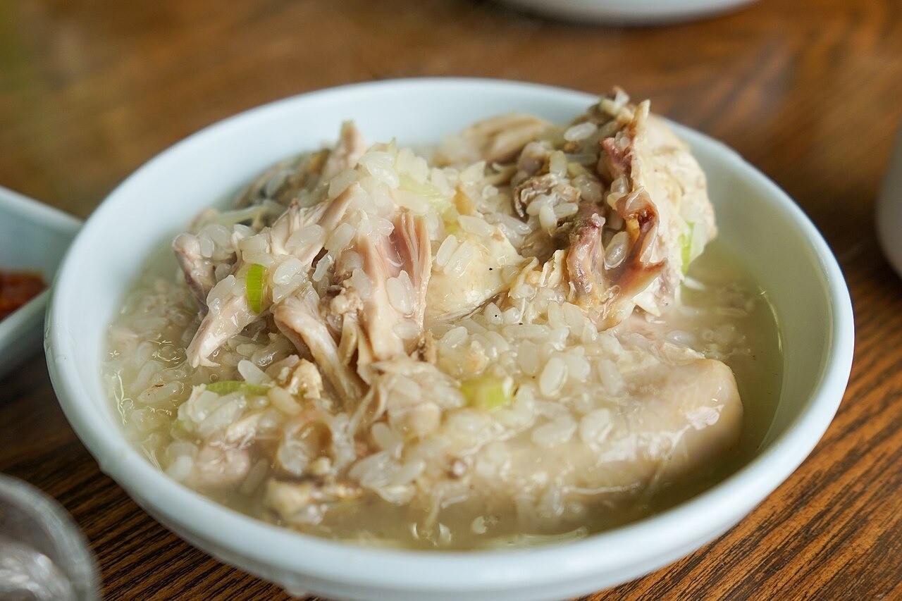 鶏をほぐしながら、スープとご飯を匙で食べる。