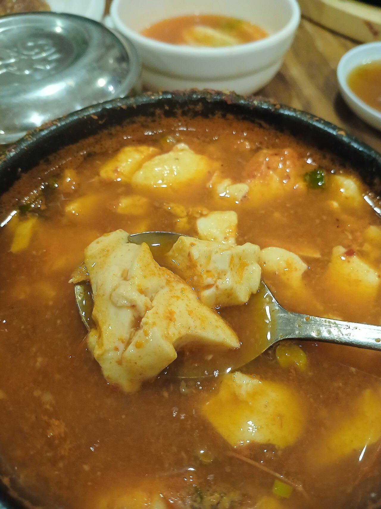 魚介や肉を加えた鍋から、豆腐をすくう。