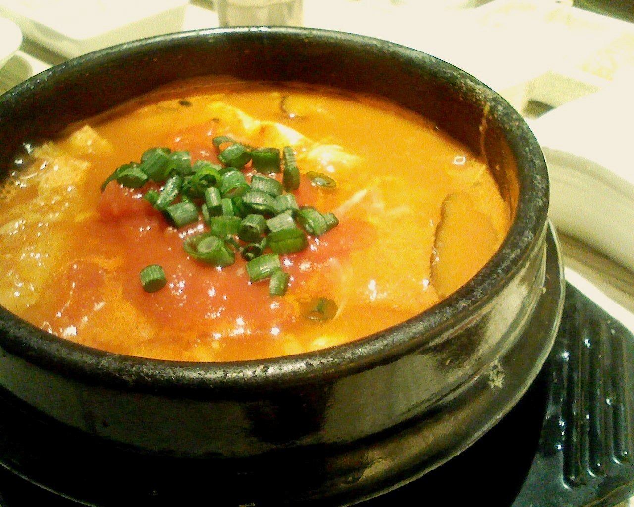 ねぎをのせた、橙色の豆腐スープ。