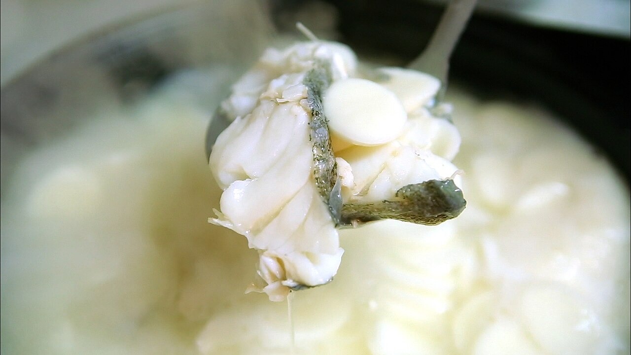 牡蠣入りトッククを、餅とともに匙ですくう。
