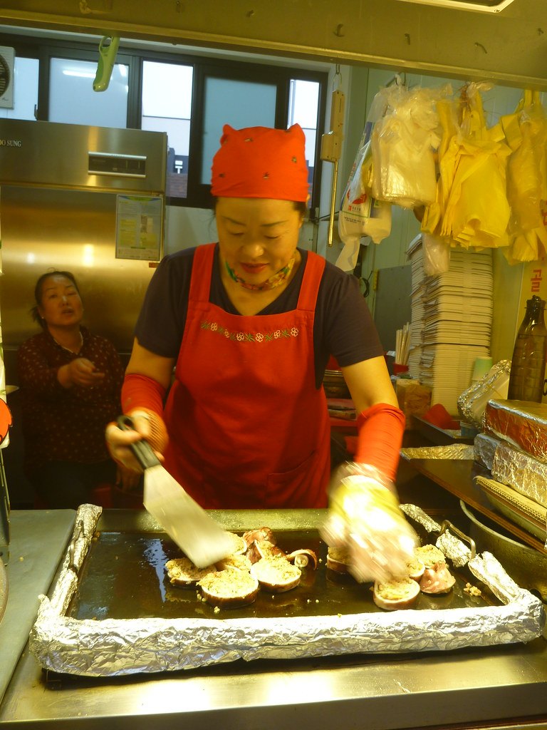 鉄板でスンデを焼く店の人。
