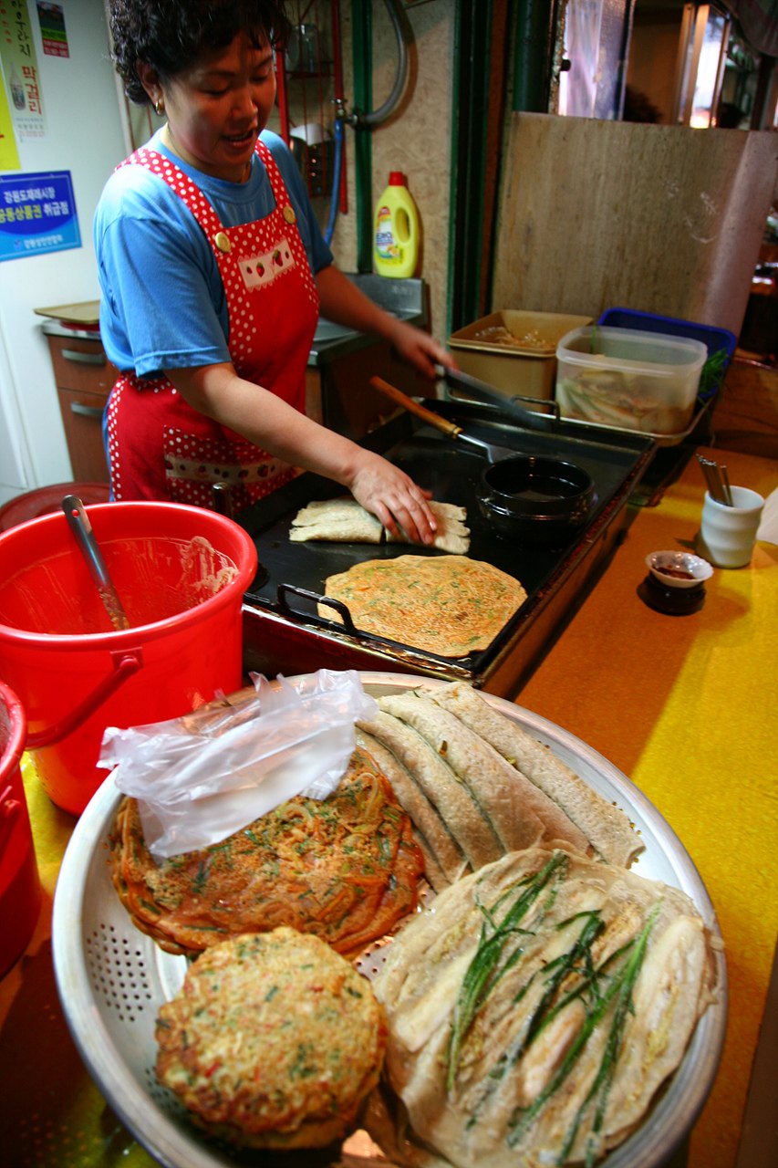 市場の鉄板の前で焼く人。