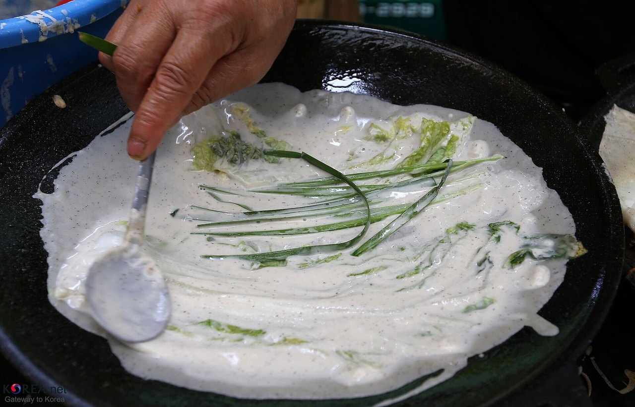 そば粉の生地を鉄板に薄く広げる。