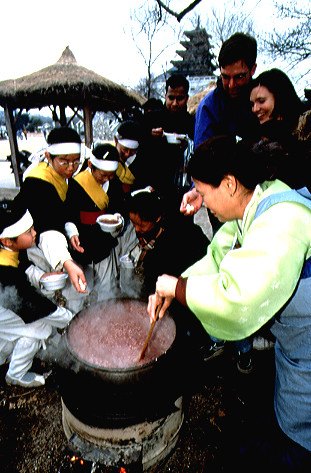 大鍋で小豆の粥を煮る人々。