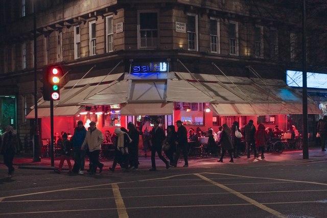 夜のエッジウェア・ロードとシーモア・ストリートの角、赤く光るレバノン料理店のテラスと行き交う人