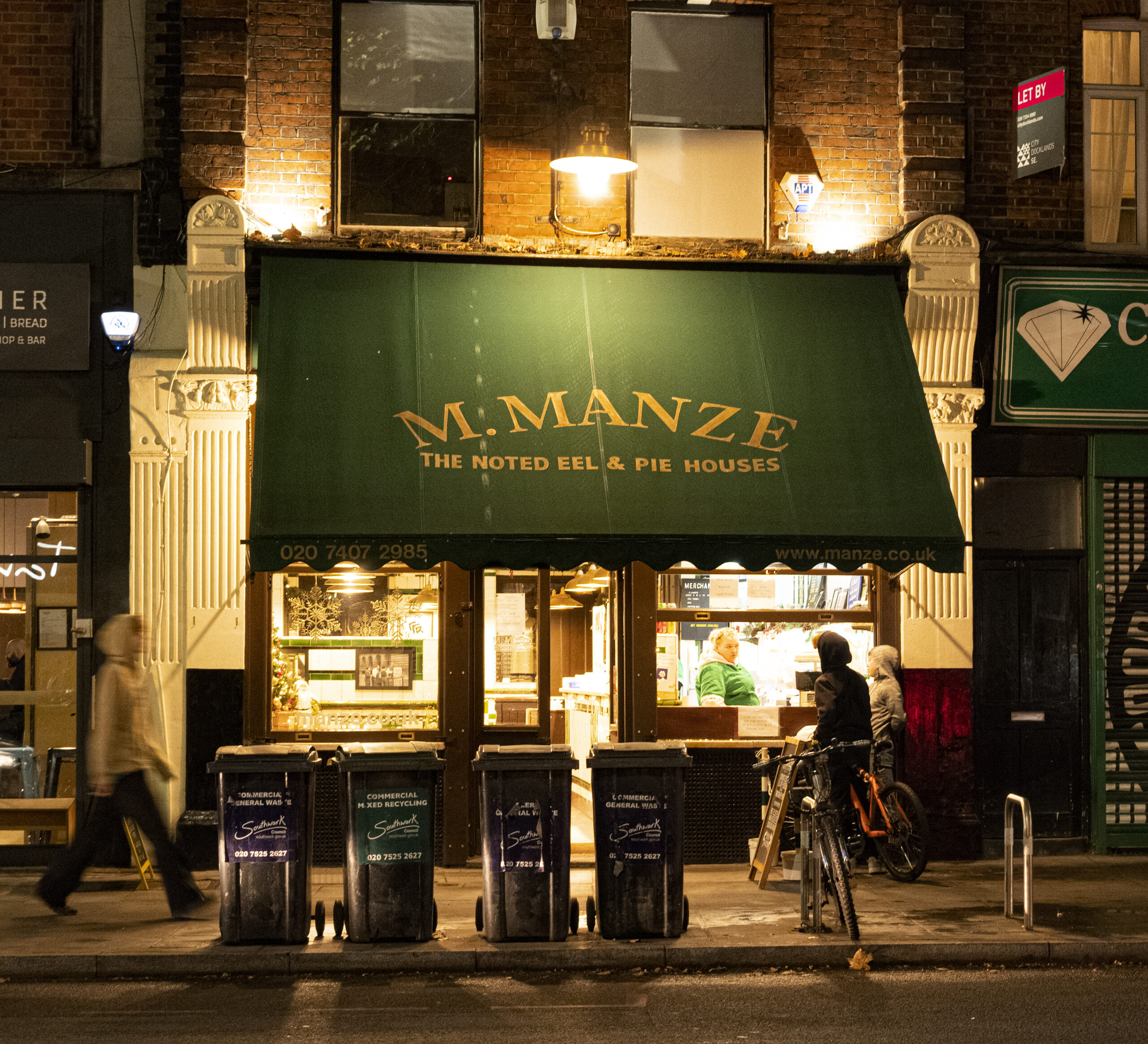 夜の M.Manze（Tower Bridge Road）の店先、緑の日よけ