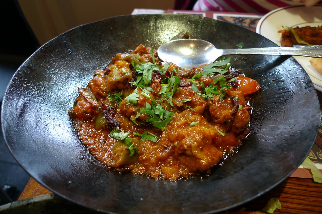 タイヤブスの黒い鉄鍋（カラヒ）に入った肉のカラヒ。香菜がのり、スプーンが差してある