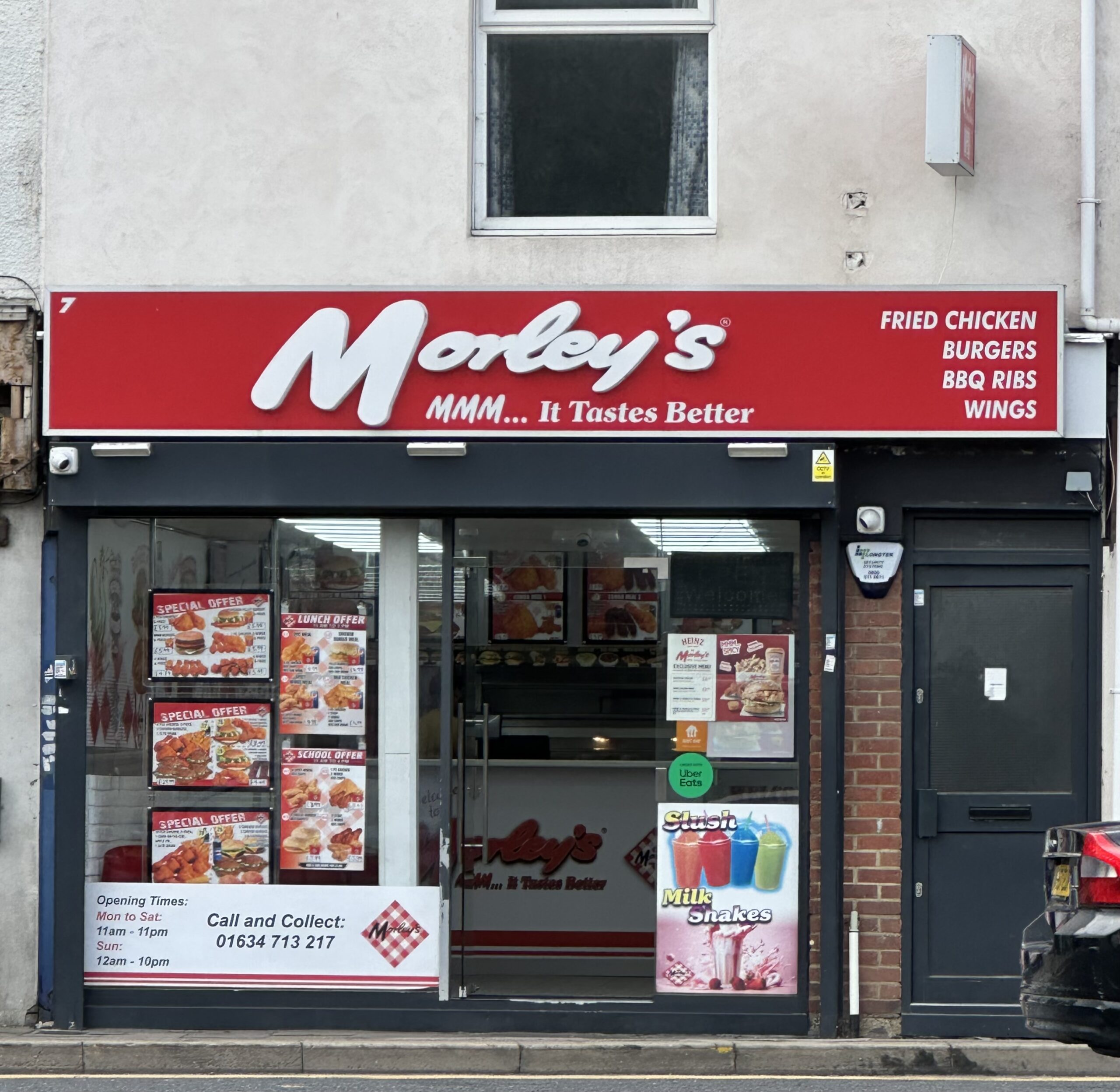 赤い看板に白い文字の Morley's の店先。窓にメニューの写真が貼られている