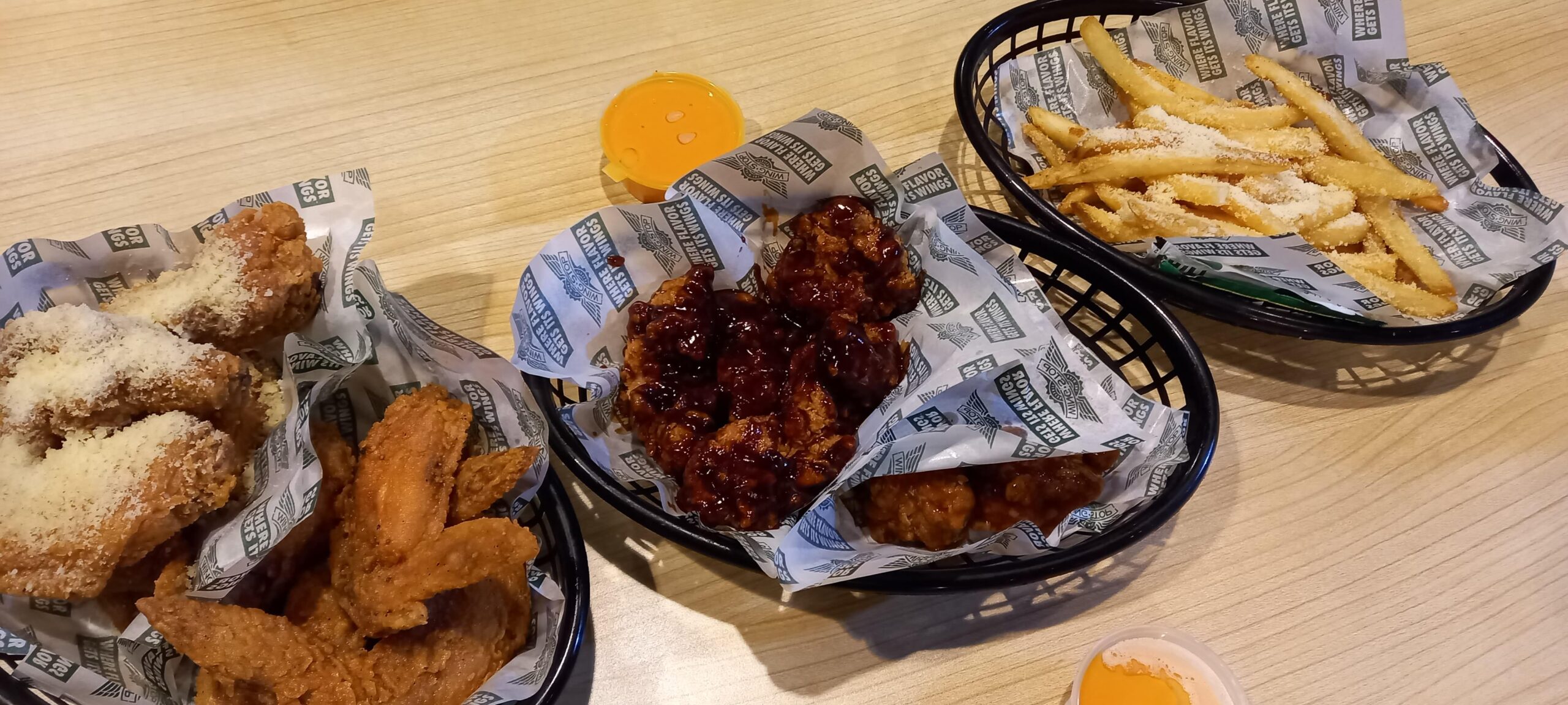 トレーのかごに入った揚げた手羽とチップス