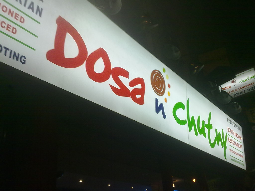 夜に光るドーサ・ン・チャトニーの看板。赤い「Dosa」と緑の「chutny」の文字