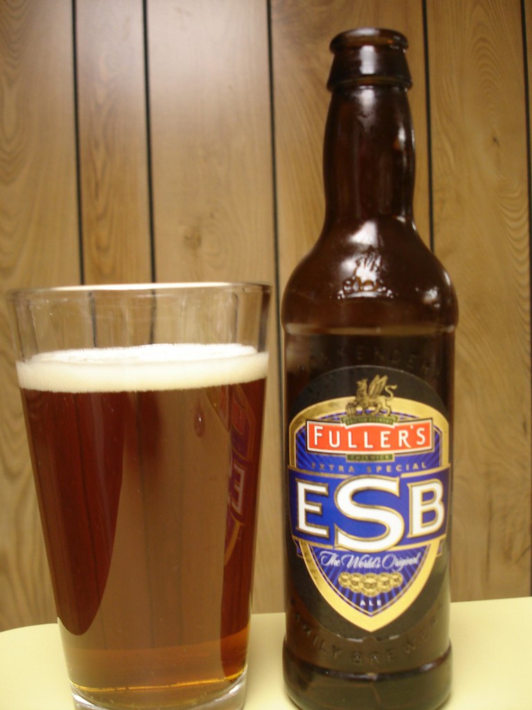 木の壁の前に、琥珀色のビールのグラスとFuller's ESBの瓶