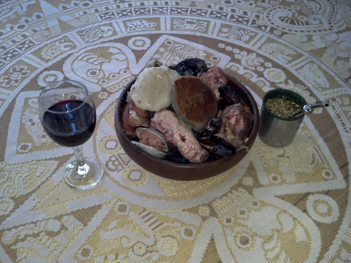 貝と肉を盛った器に添えられたミルカオとチャパレレ、赤ワインのグラス