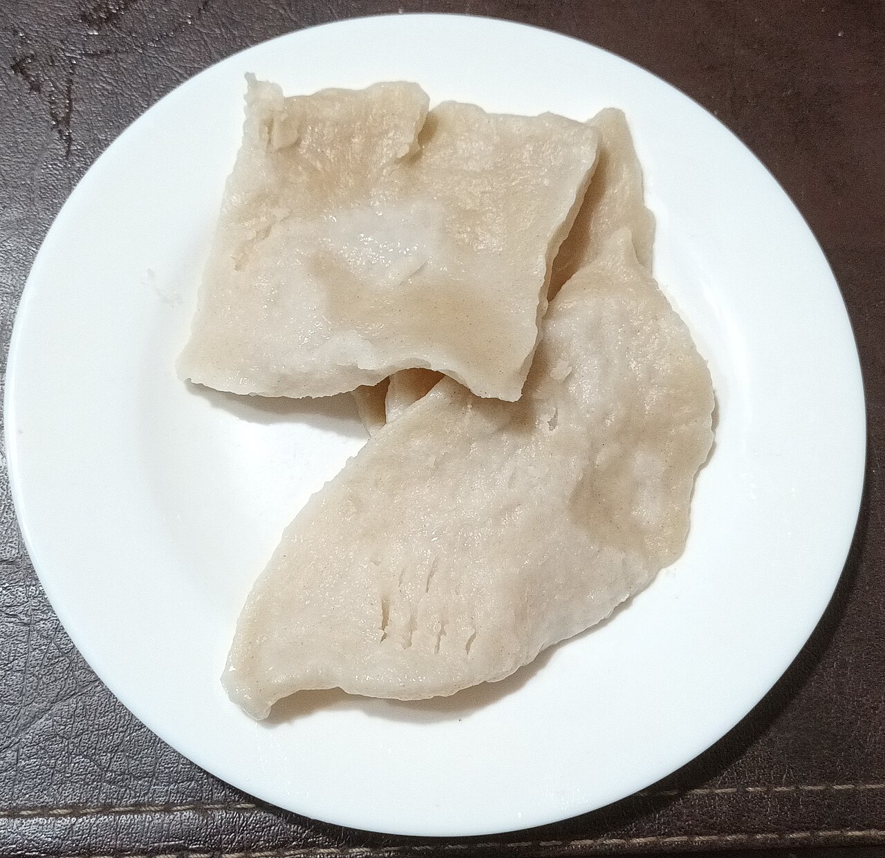 白い皿に置かれた、平たく茹で上げられた二枚のチャパレレ
