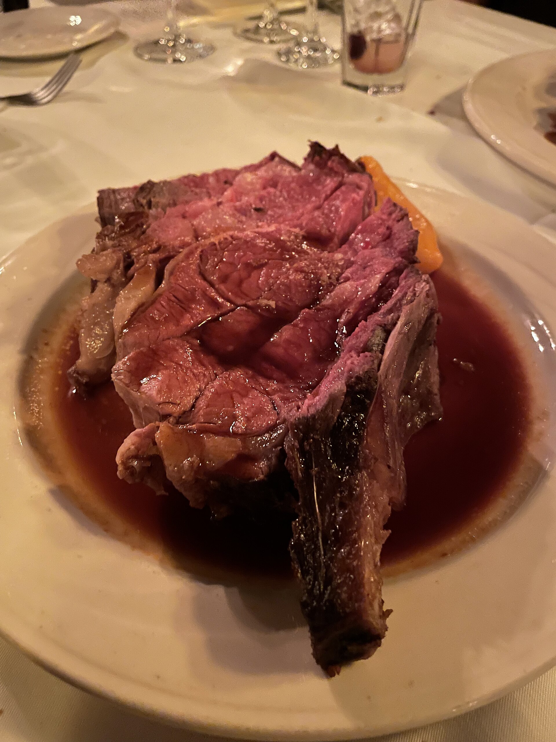 白い皿に立てて盛った骨付きの厚いマトン・チョップと肉汁