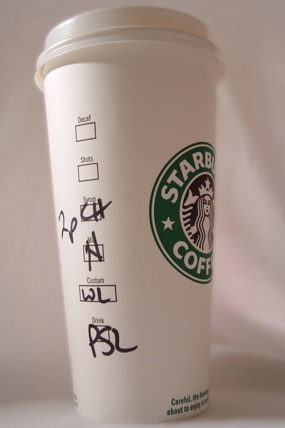 「PSL」と手書きされたスターバックスの白い紙カップ