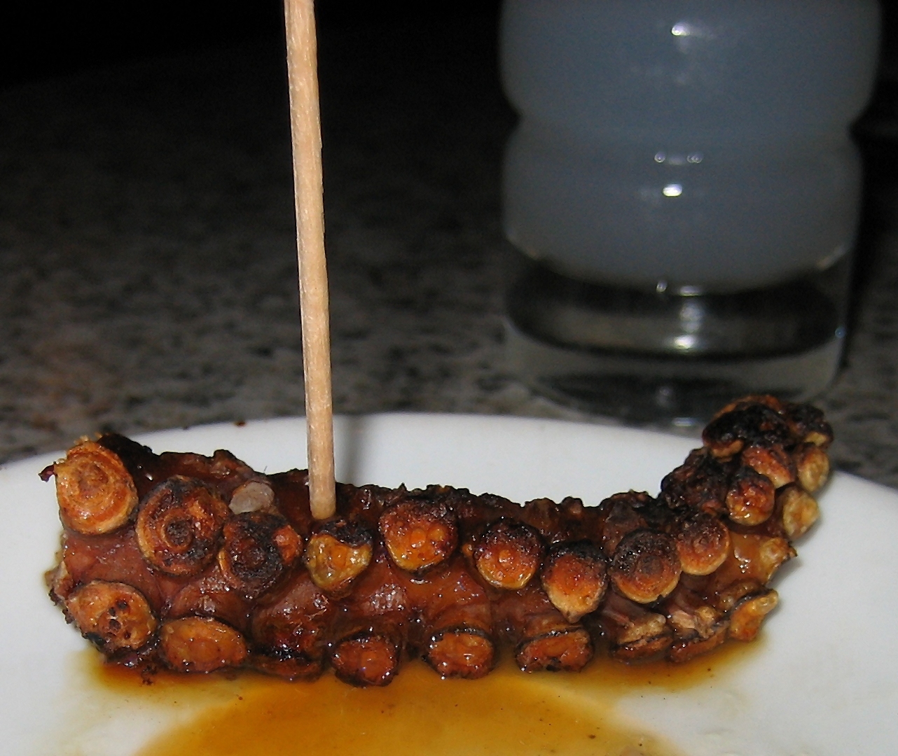 串に刺したタコの足の炭火焼きとウーゾ