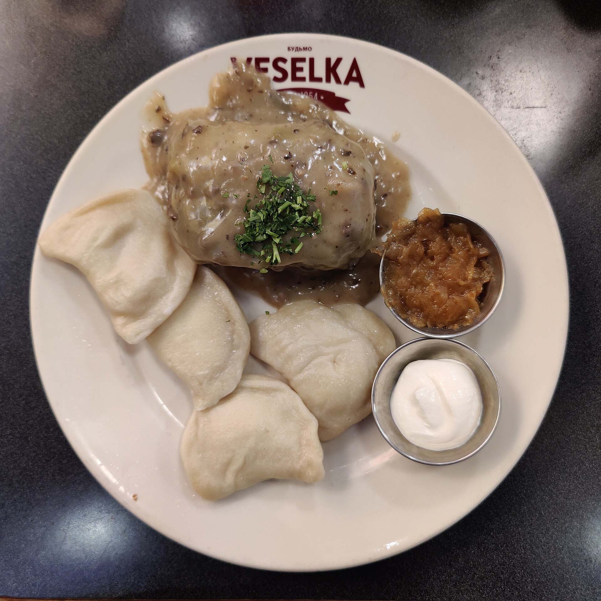 Veselka のロゴ入り皿、茹でたピエロギとロールキャベツ、サワークリーム