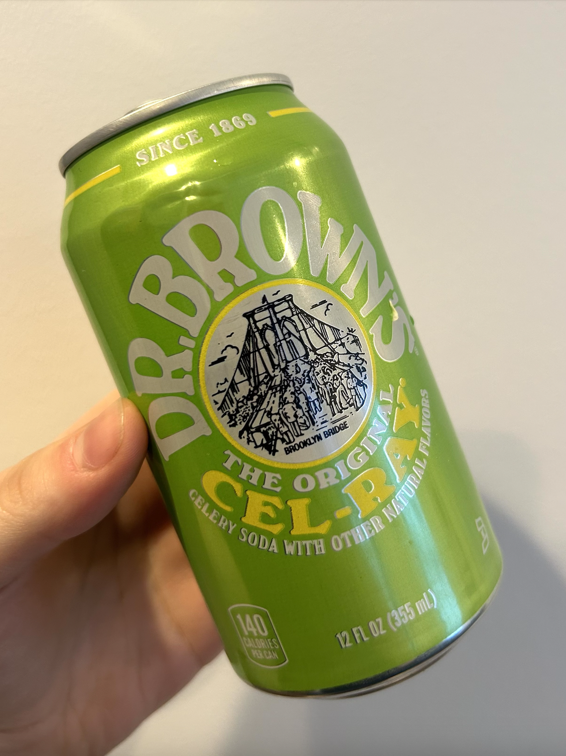 手に持った緑色の Dr. Brown's Cel-Ray の缶