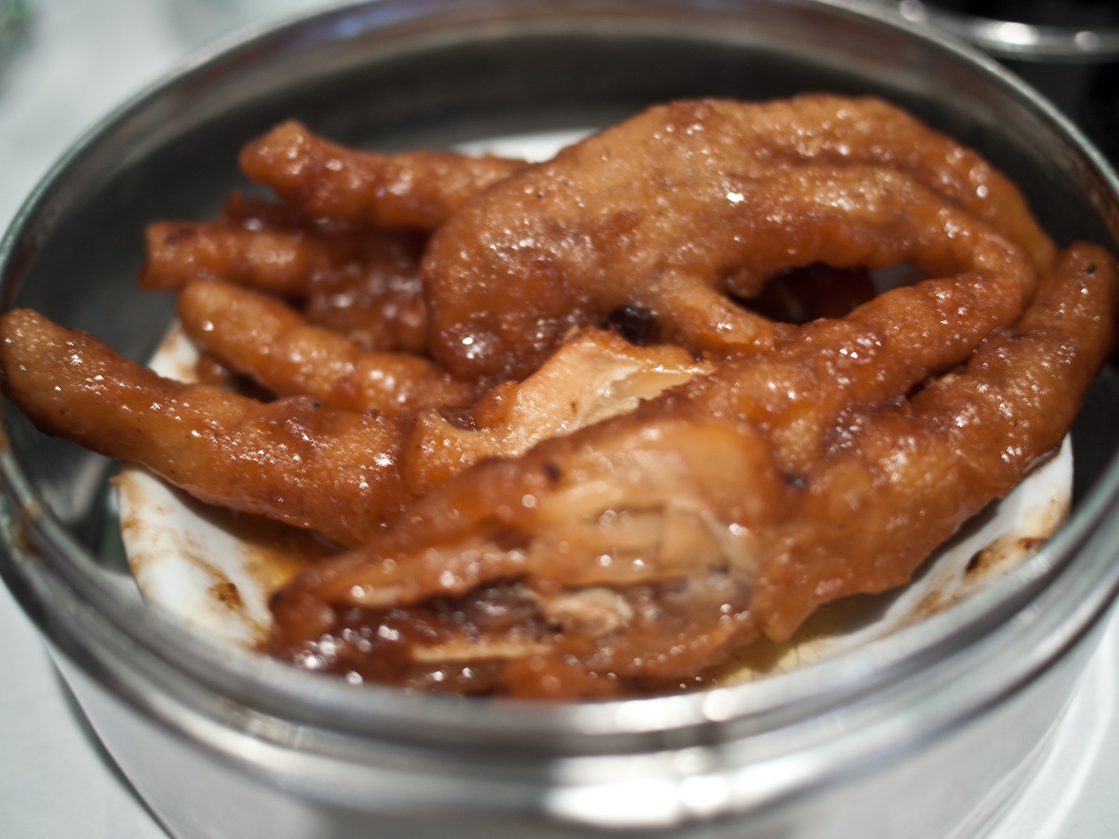 蒸し器に盛った、甘辛いたれで煮た鳳爪（鶏の足）