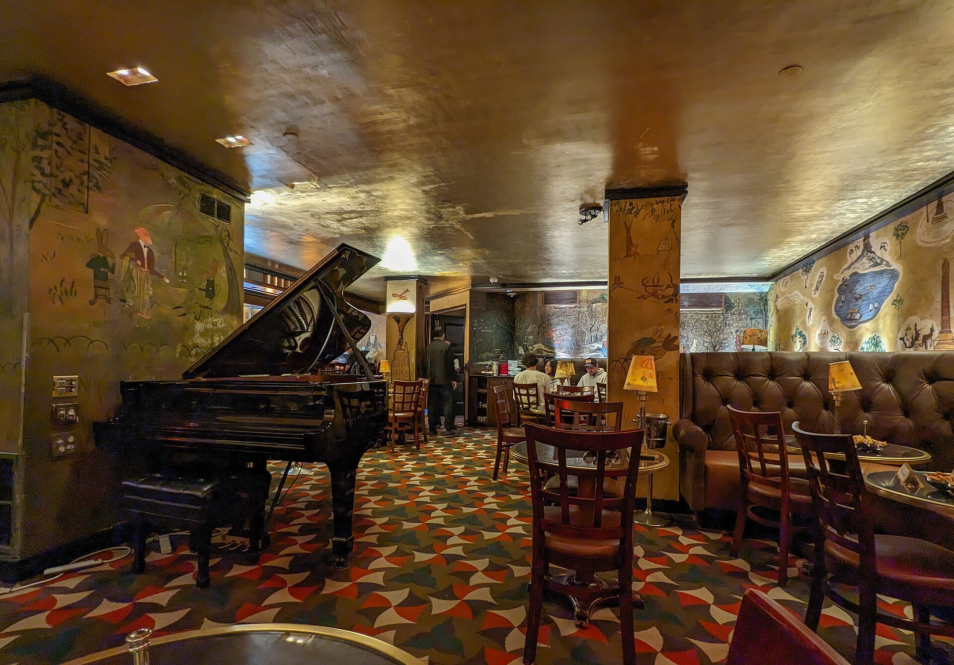金箔の天井とグランドピアノ、ベーメルマンスの壁画がある Bemelmans Bar の店内