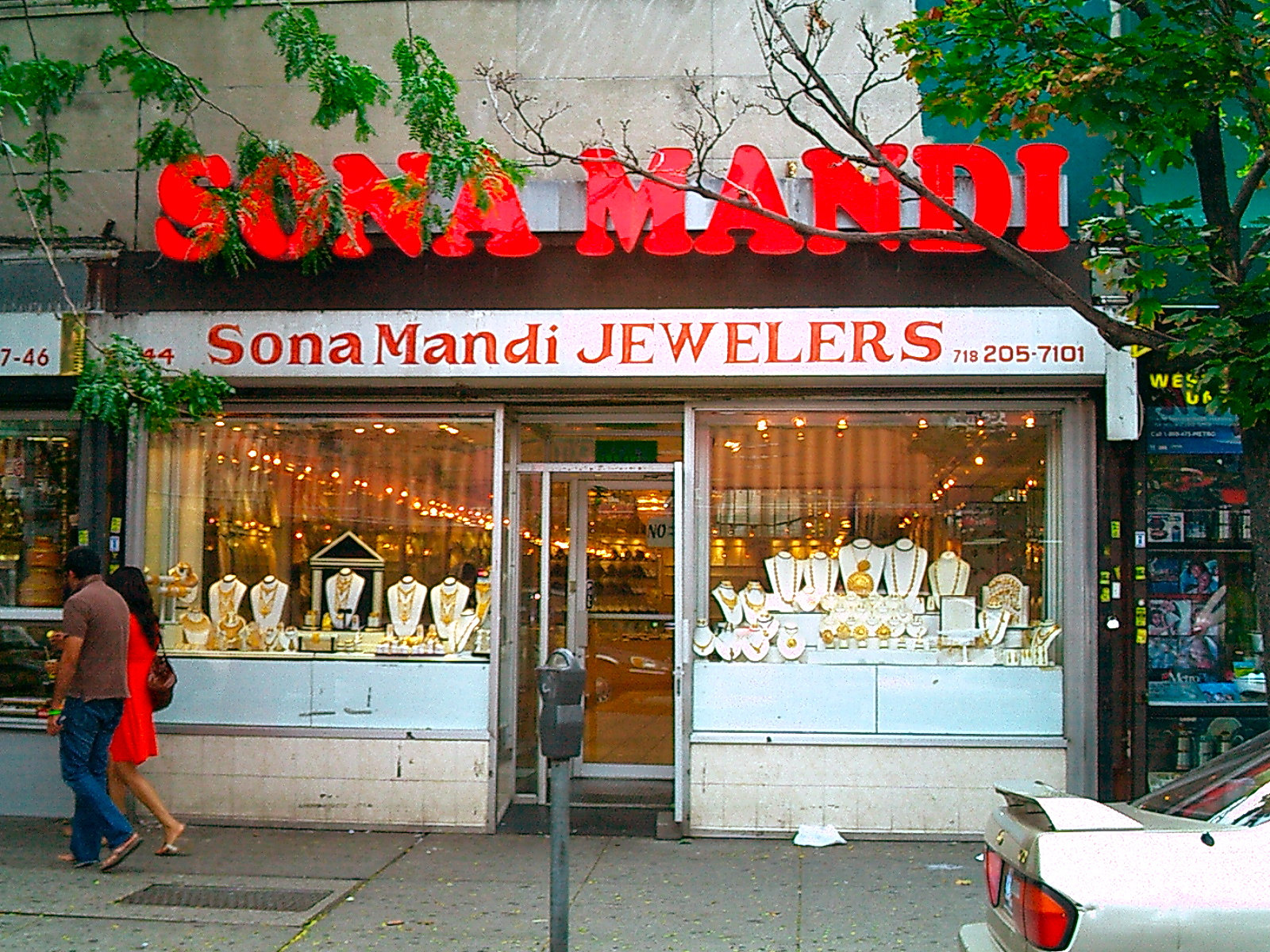赤い看板の Sona Mandi Jewelers、金の宝飾品が並ぶ店先