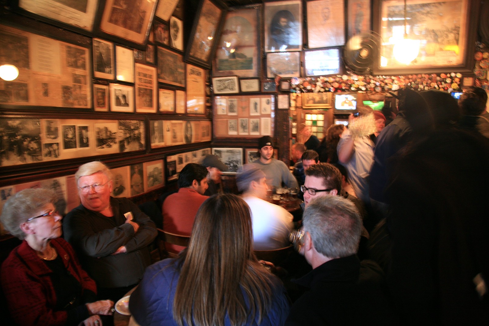 額がびっしり掛かった McSorley's の店内と客