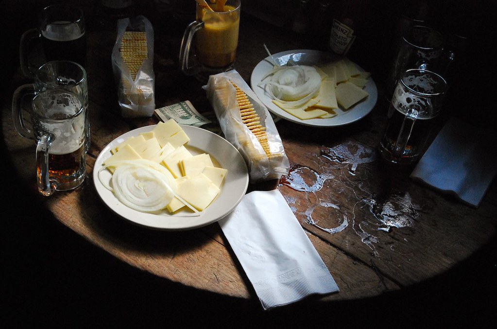 McSorley's のテーブルのチーズ皿と生玉ねぎ、ジョッキ