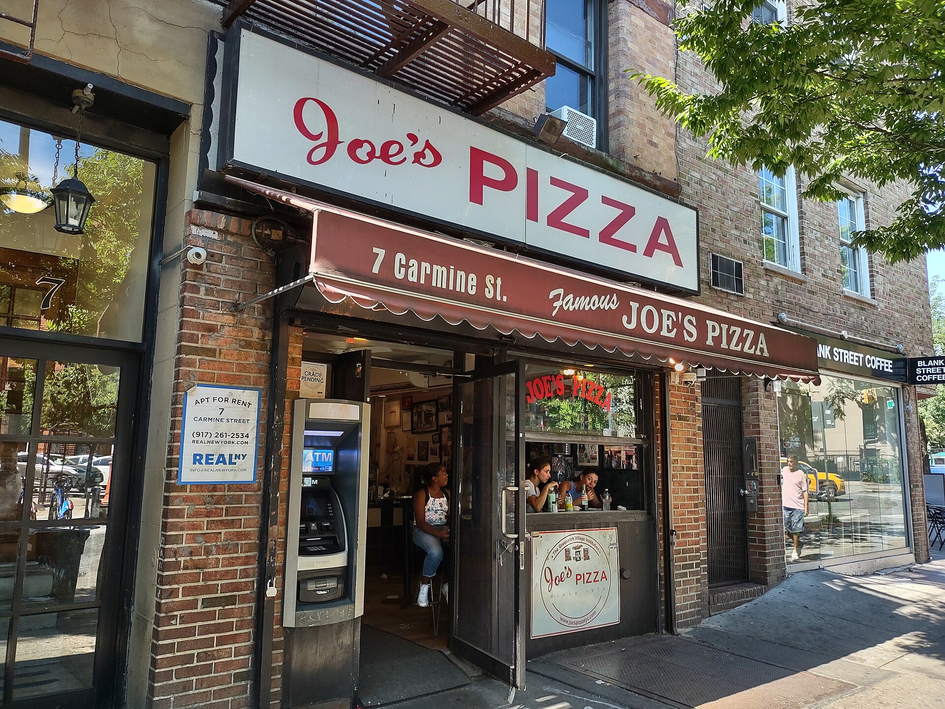 カーマイン通り7番地の Joe's Pizza の店先、赤い日よけ