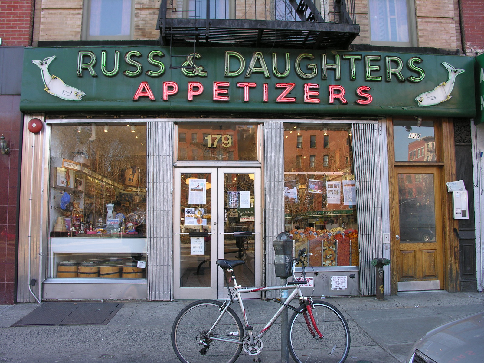 緑の看板に「RUSS & DAUGHTERS APPETIZERS」、179番地の店先と自転車