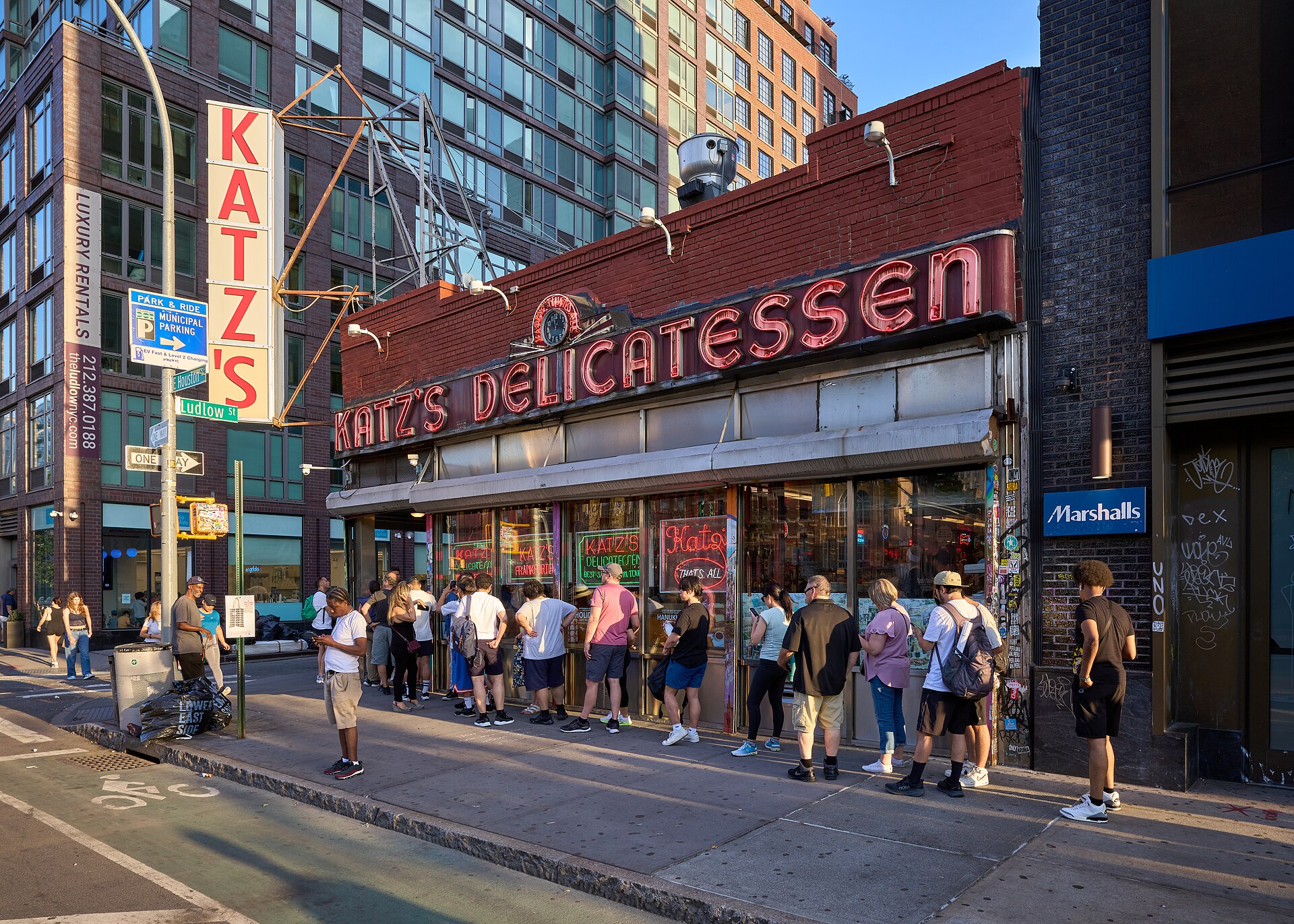 赤れんがに「KATZ'S DELICATESSEN」のネオン看板、角の店先に並ぶ行列