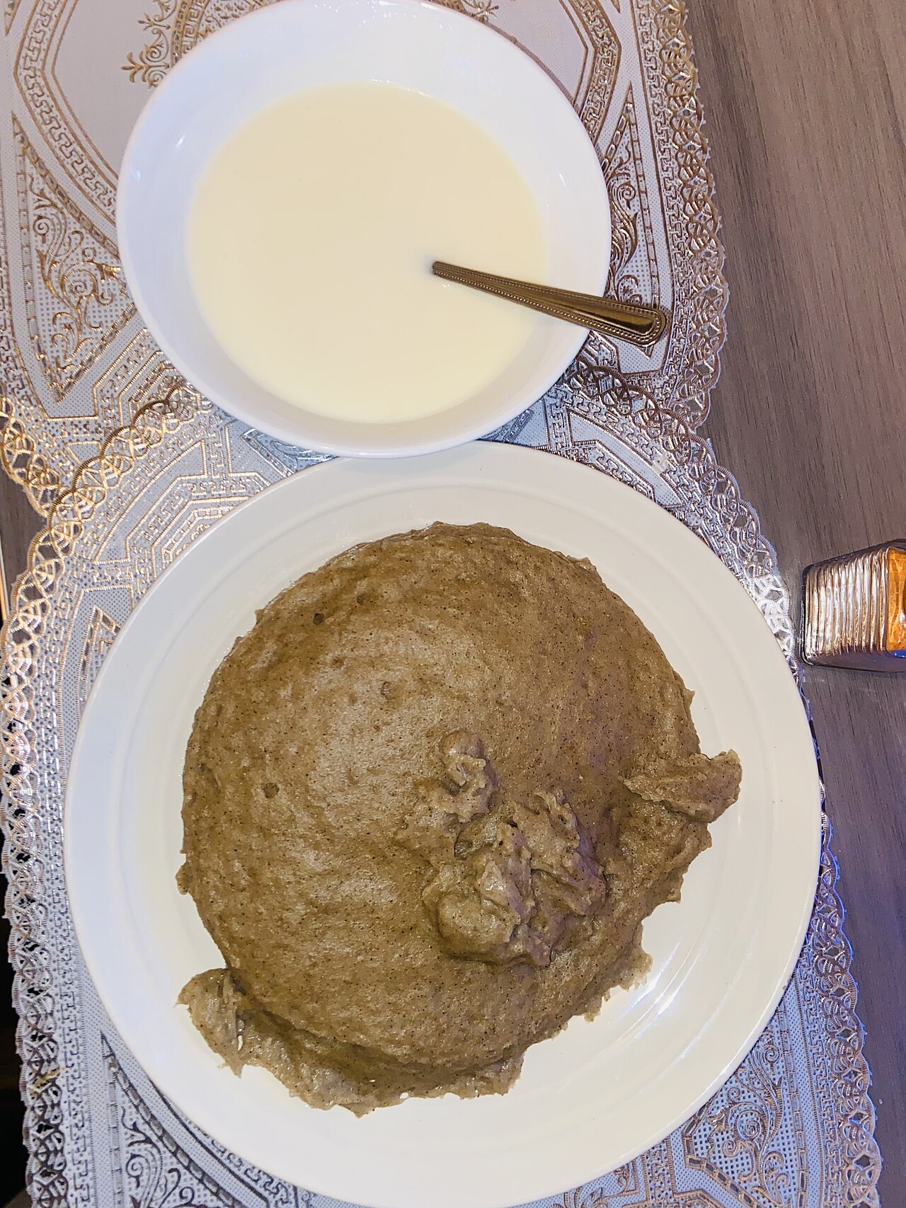 白い皿に盛られたマハングの練り粥と、牛乳を入れた器