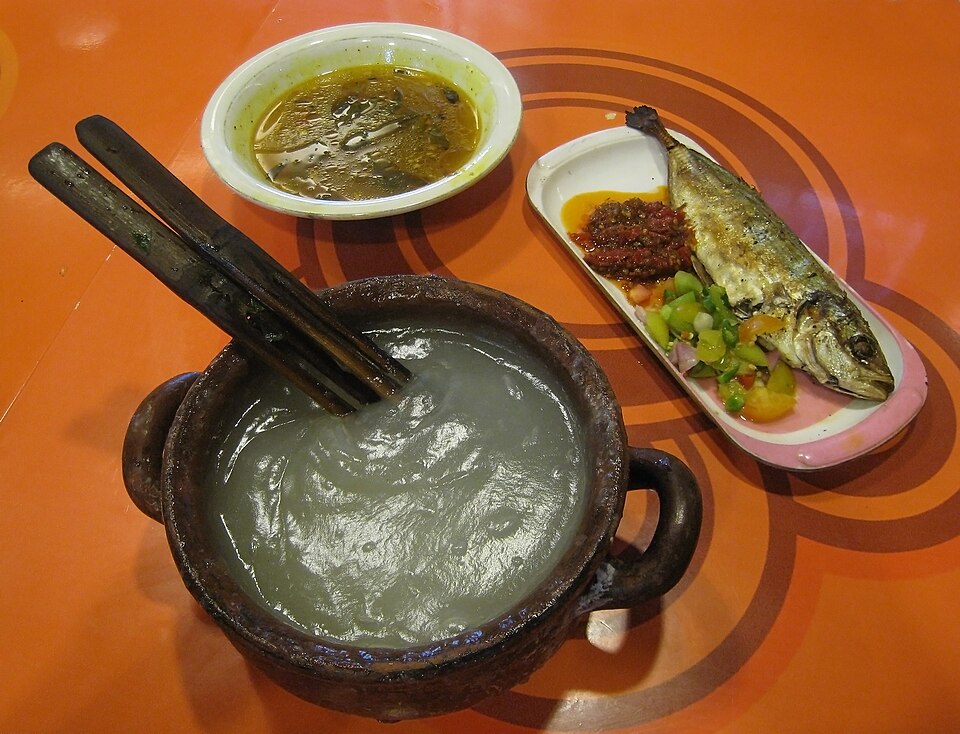素焼きの器に入った半透明のパペダと、専用の二股の道具ガタガタ、黄色い魚のスープ、焼いたアジ