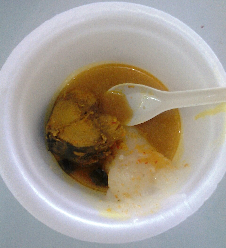 器に入った魚入りの黄色いスープと、その中に沈む白いパペダ