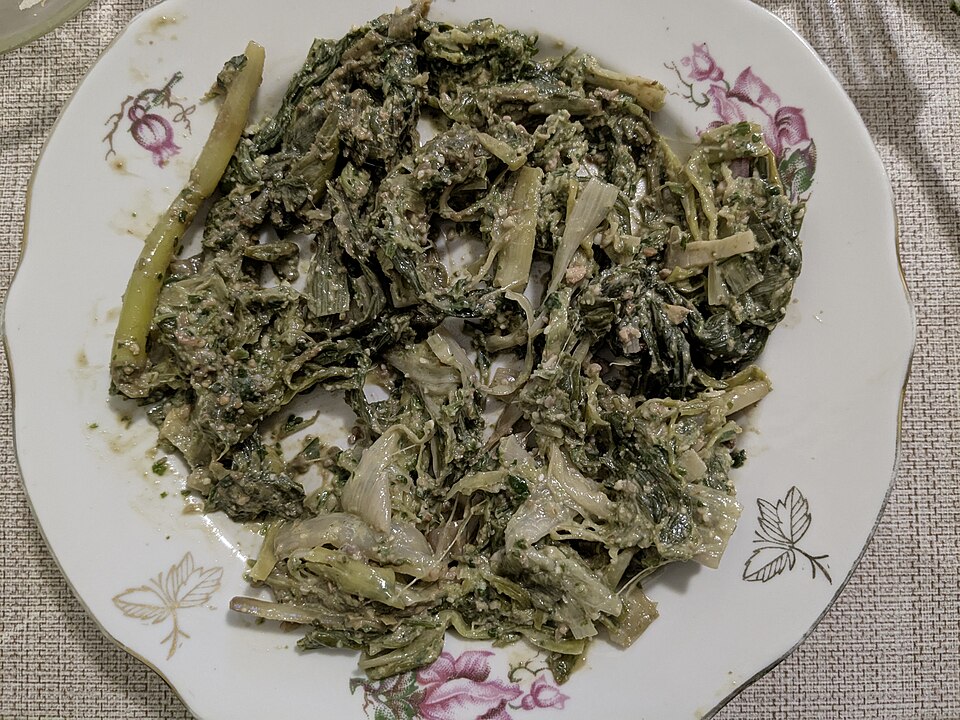 白い皿に盛られた、下茹でしたリーキとくるみペーストの和え物