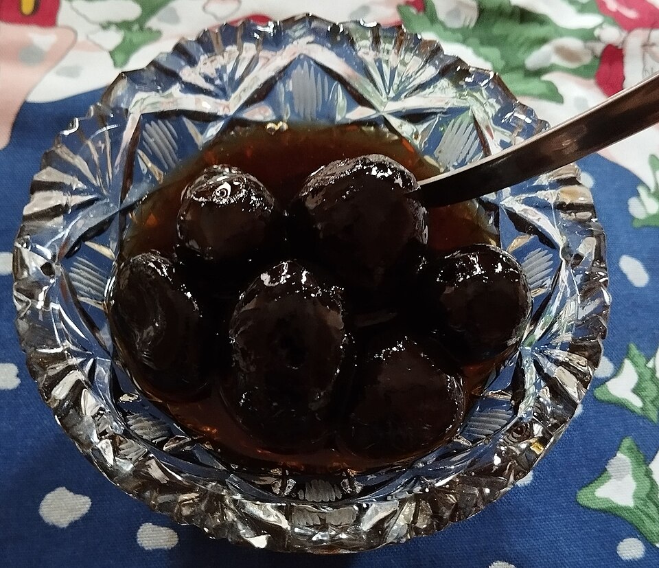 ガラスの器に入った、濃い色の青ぐるみの砂糖煮