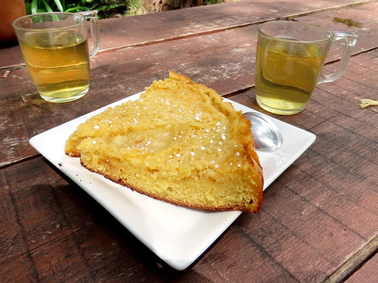 白い皿にのせた三角形のガトー・ティ・ソンと、2杯のお茶