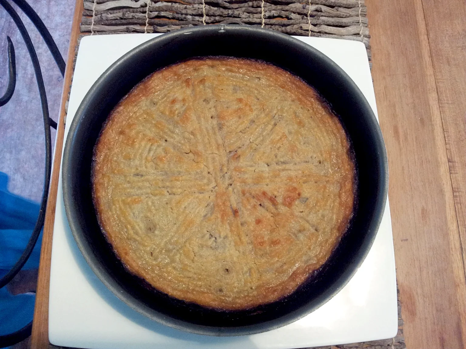 黒い丸皿に焼き上げたガトー・パタト（さつまいもの菓子）