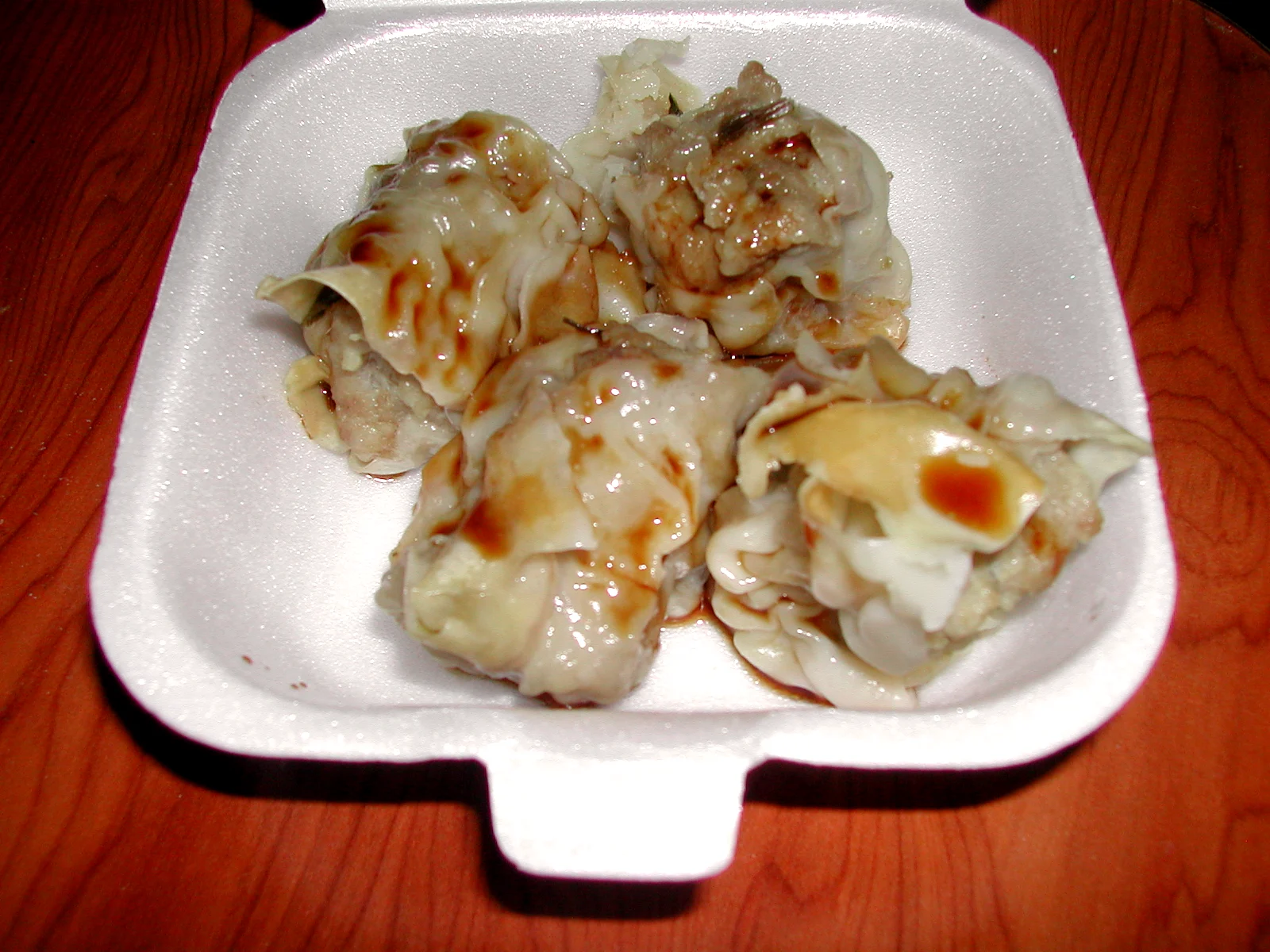 発泡トレーに入った、たれのかかったブション（蒸し餃子）
