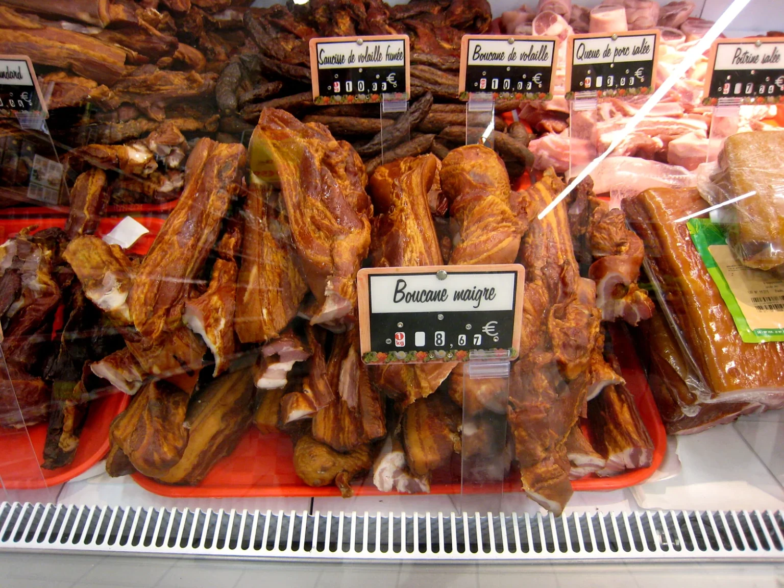 「Boucané maigre」の札をつけた赤身の燻製豚の売り場