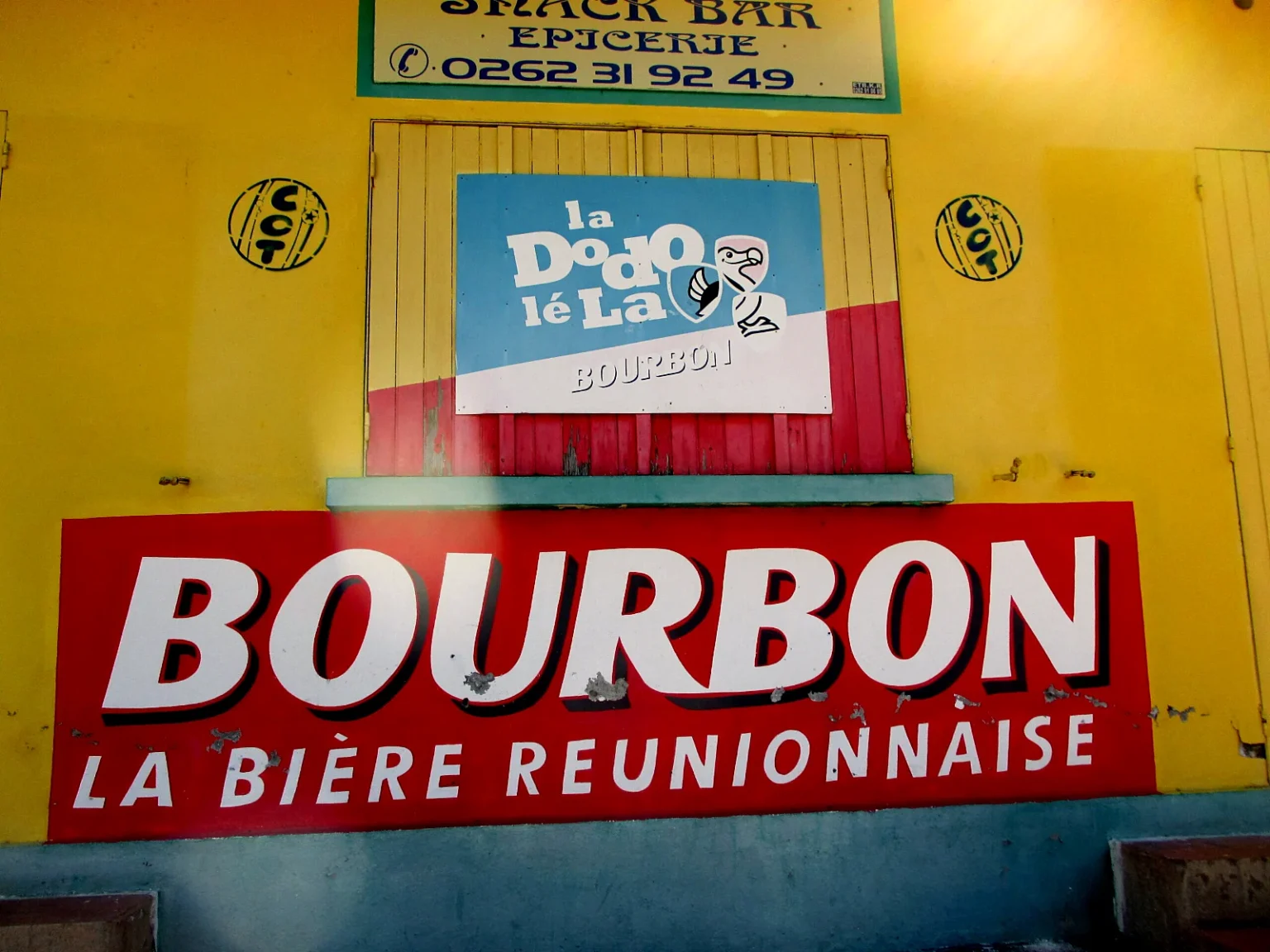 黄色い商店の壁に掲げられた「BOURBON LA BIÈRE RÉUNIONNAISE」の看板