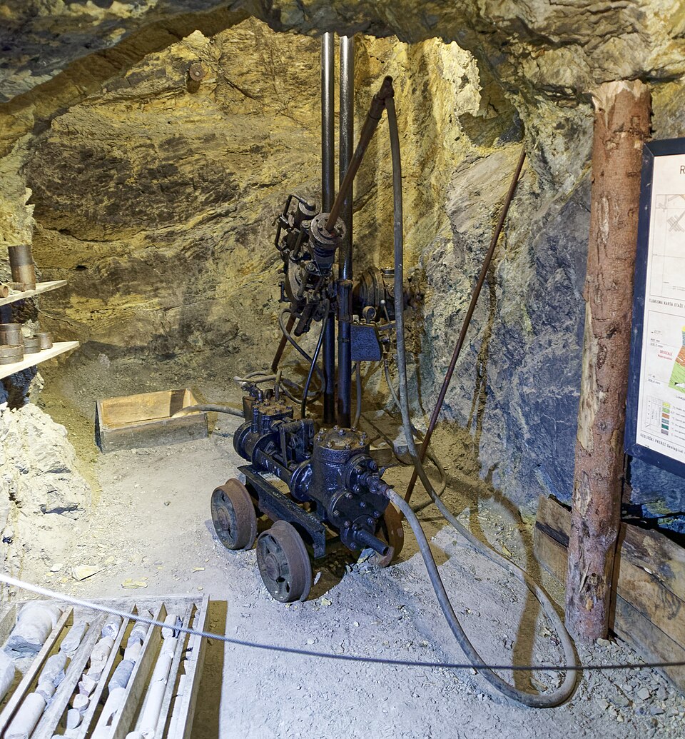 黄色い岩肌の坑道に据えられた古い削岩機