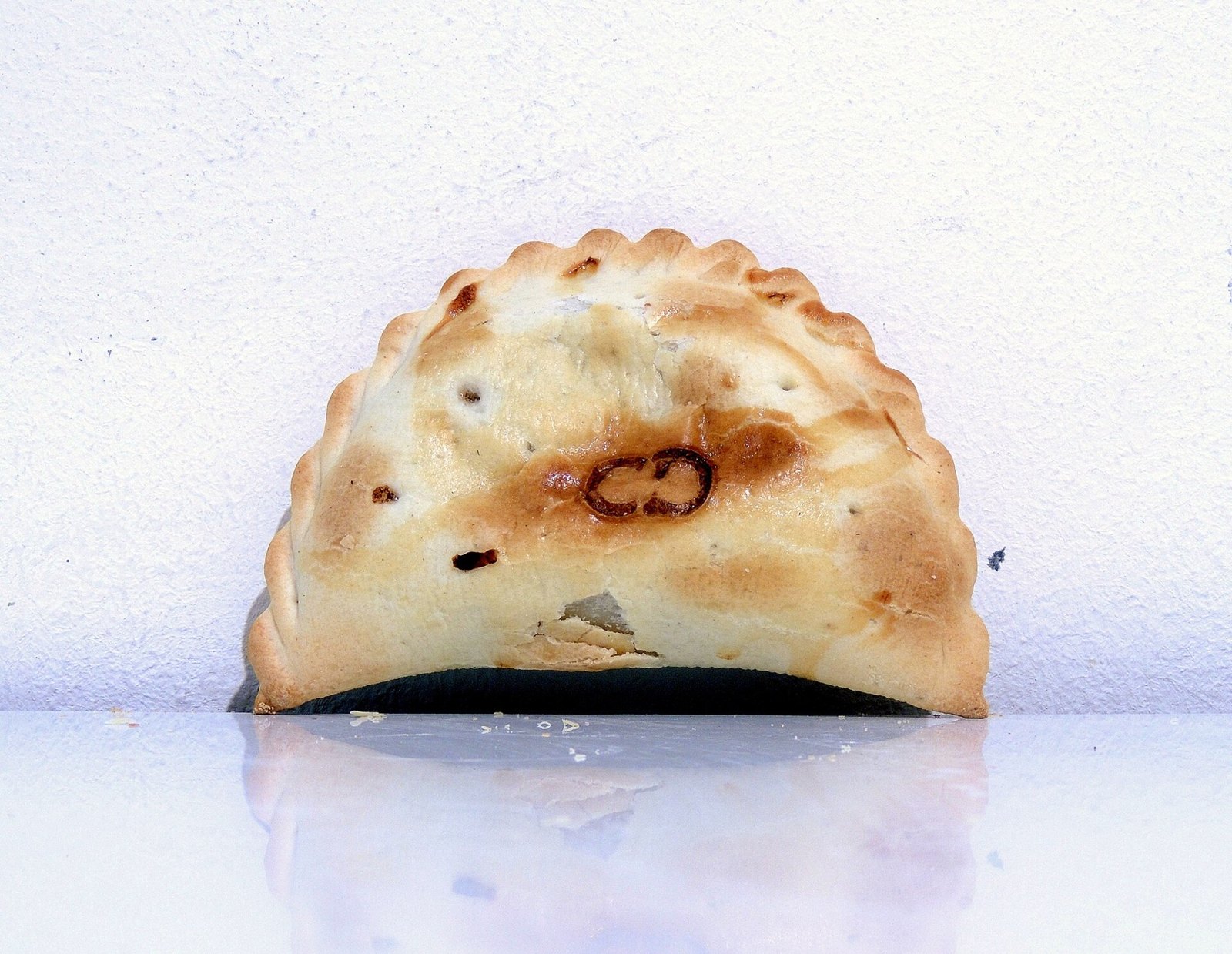 アルゼンチン式エンパナーダの一例（2013年）。写真は甘めの肉の具を包んだもの。具や焼き方は地域・店で異なる。
