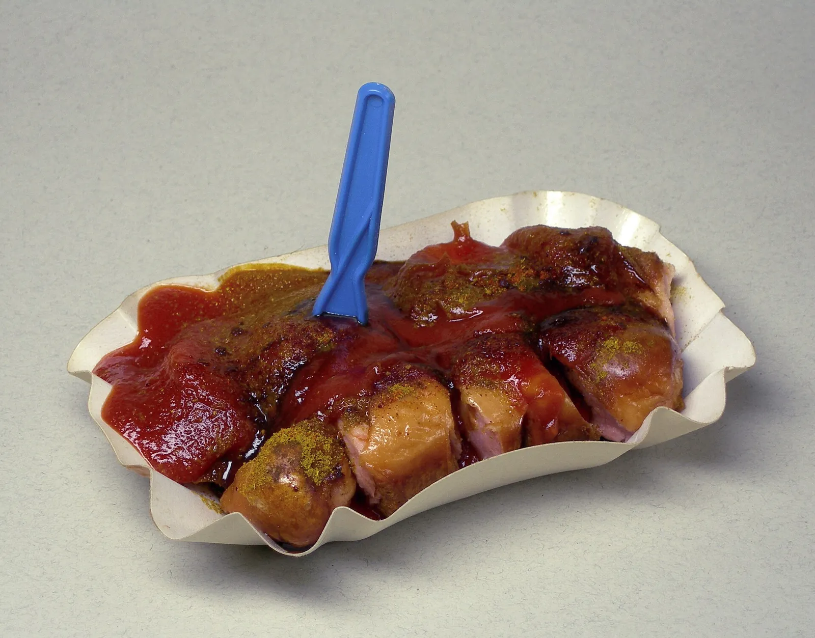 ひと口ずつ切ったソーセージに赤いソースとカレー粉をかけた、ベルリン式のカリーヴルスト。