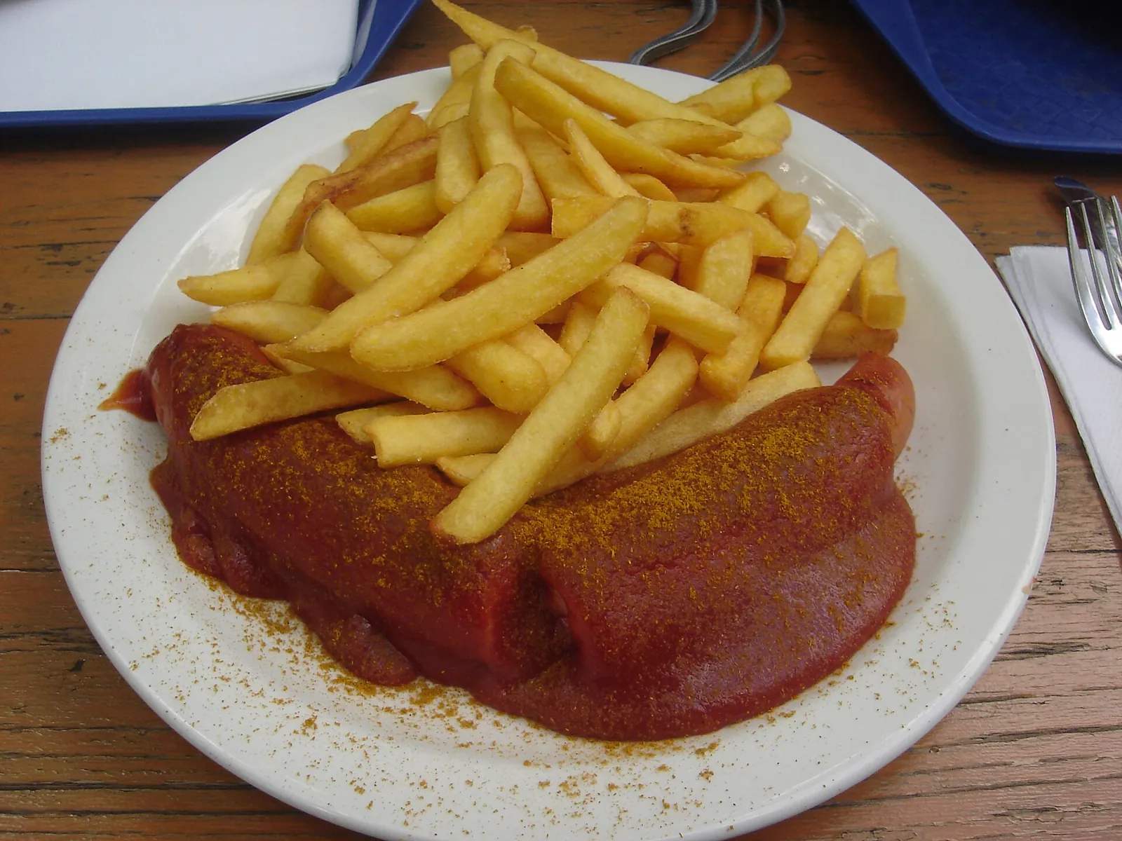 フライドポテトを添えたカリーヴルスト。ソーセージを丸ごとの形で盛っている。