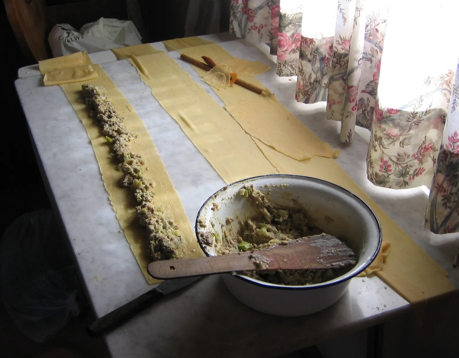 伸ばした生地の上に、肉とほうれん草のフィリングを帯状に広げる（2005年）